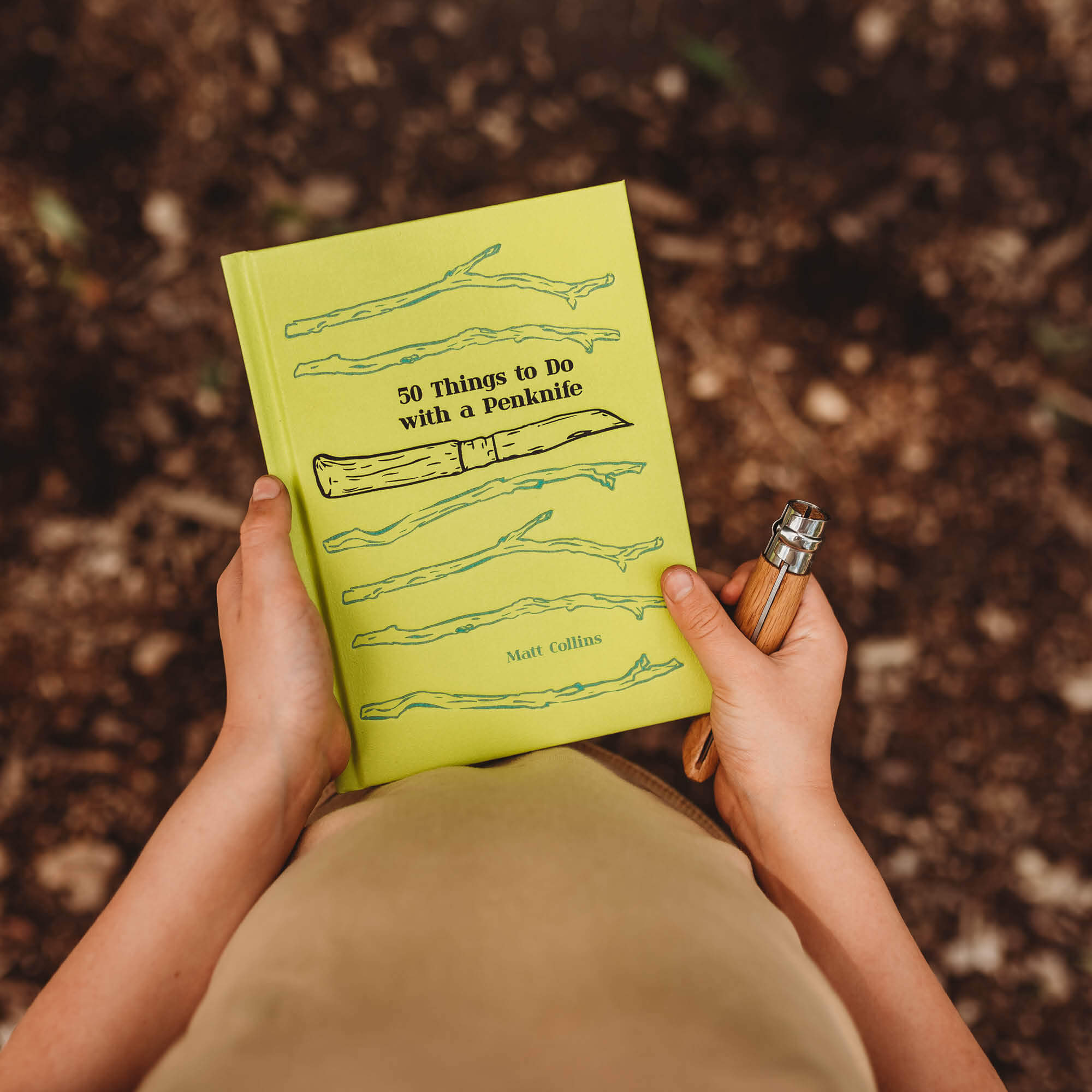 Boy holding 50 Things to do with a Penknife book by Matt Collins with advanced No08 wood whittling knife by Opinel, sold by Your Wild Books in a bundle for 13% off