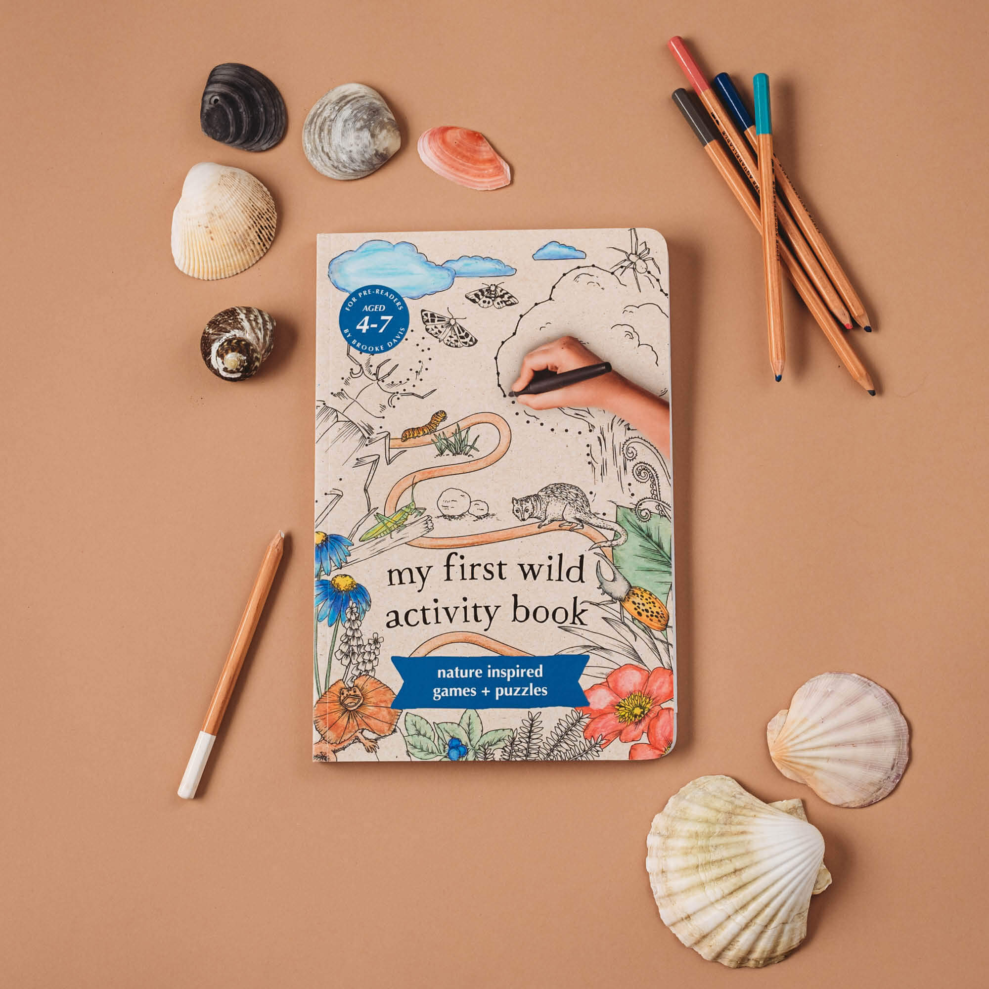 flatlay of My First Wild Activity Book made in Australia by Your Wild Books with shells and pencils
