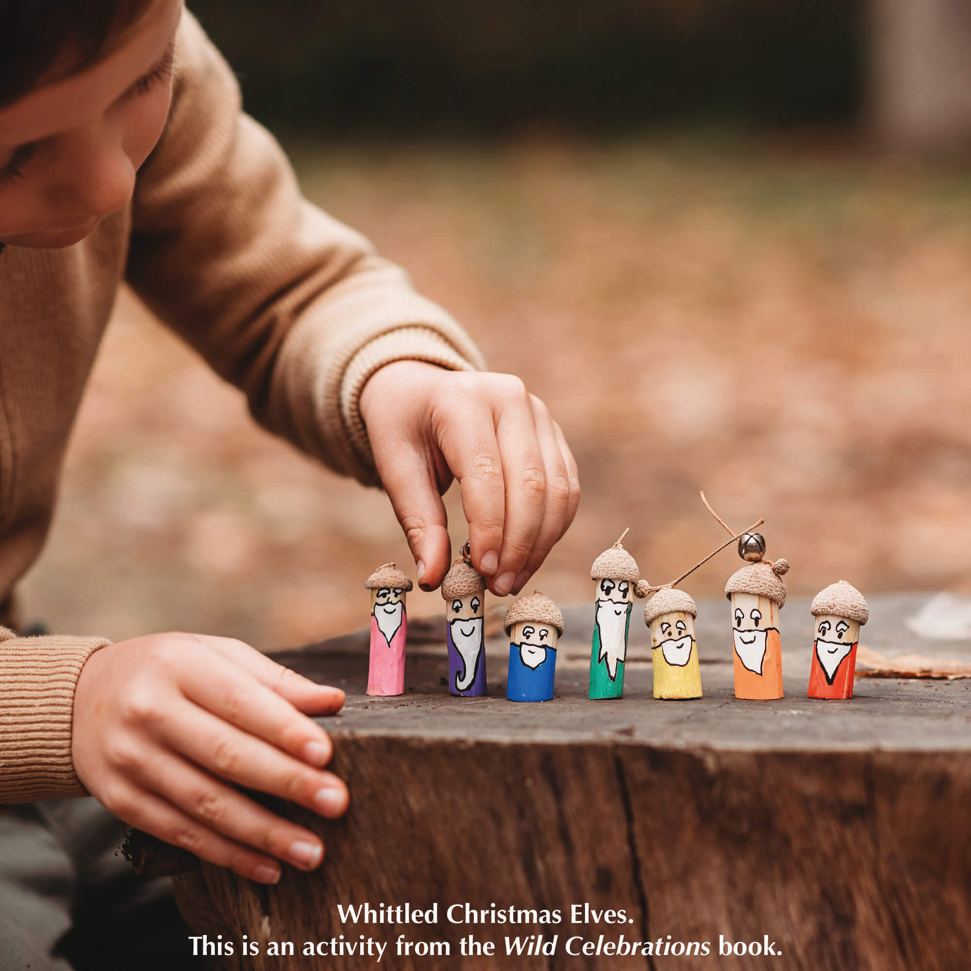 Child holding small whittled people from nature craft activity from Your Wild Books that have been decorated with paint pens from Life of Colour