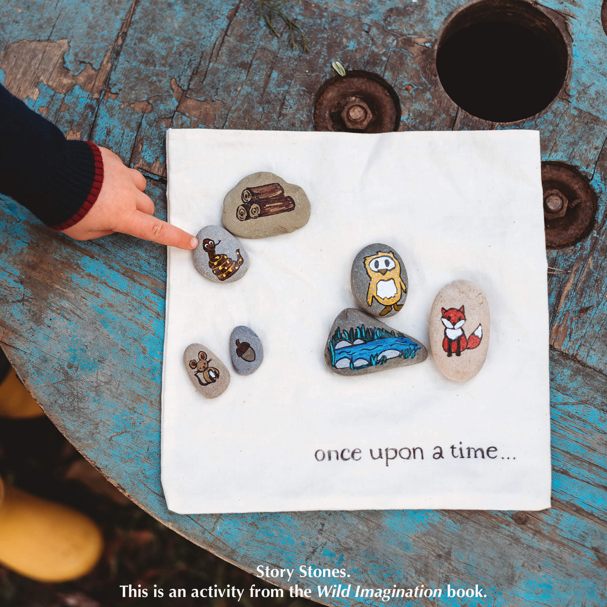 Child pointing at nature craft activity from Your Wild Books, story stones decorated in Gruffalo theme using paint pens from Life of Colour