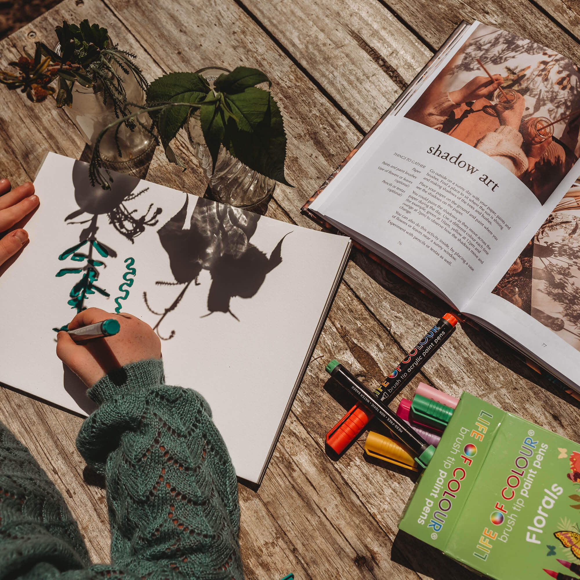 Child doing a shadow art activity using paint pens from instructions inside Wild Child, nature craft projects for kids book, made in Australia by Your Wild Books.