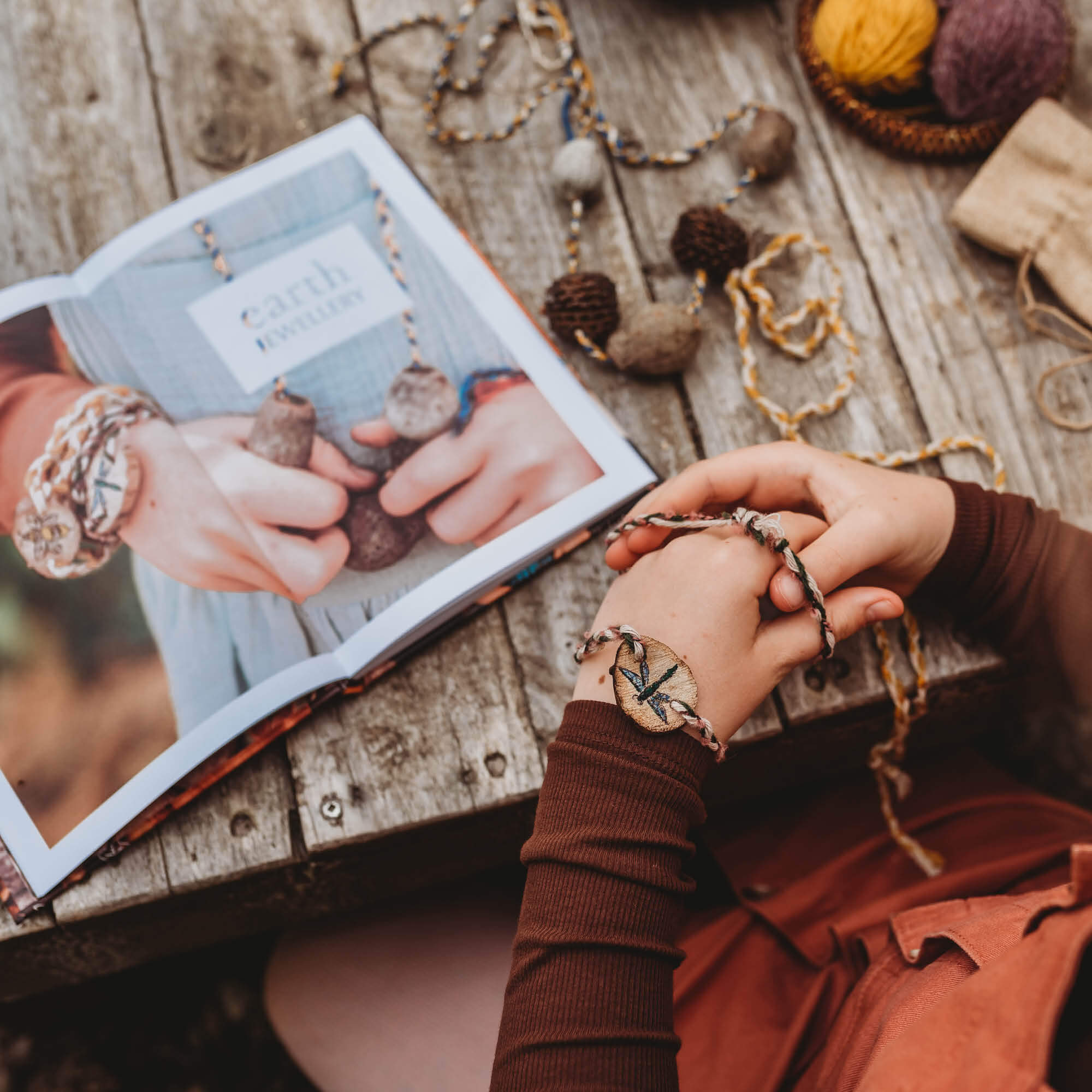 Child making Earth Jewellery using step by step instructions in Wild Child, nature craft projects for kids book, made in Australia by Your Wild Books.