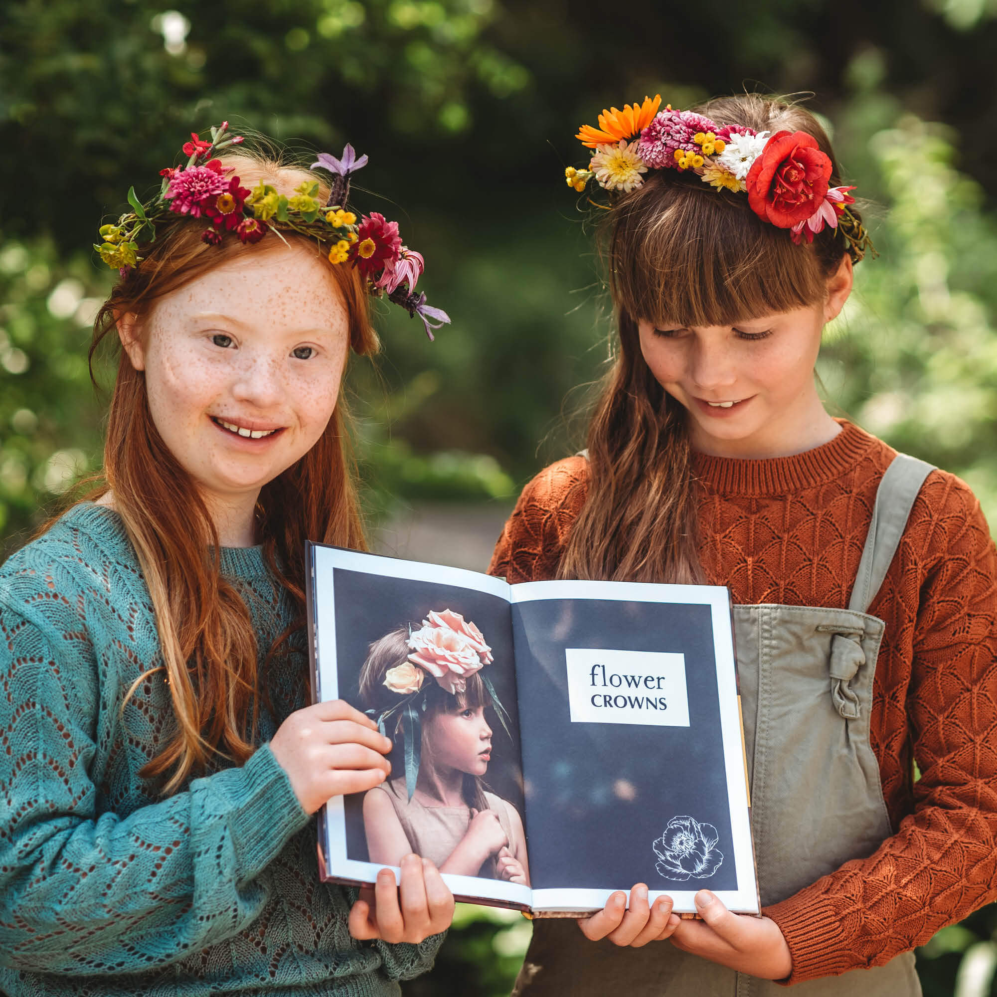 Two girls wearing flowers crowns that they made using step by step instructions inside Wild Imagination, nature craft projects for kids book, made in Australia by Your Wild Books.