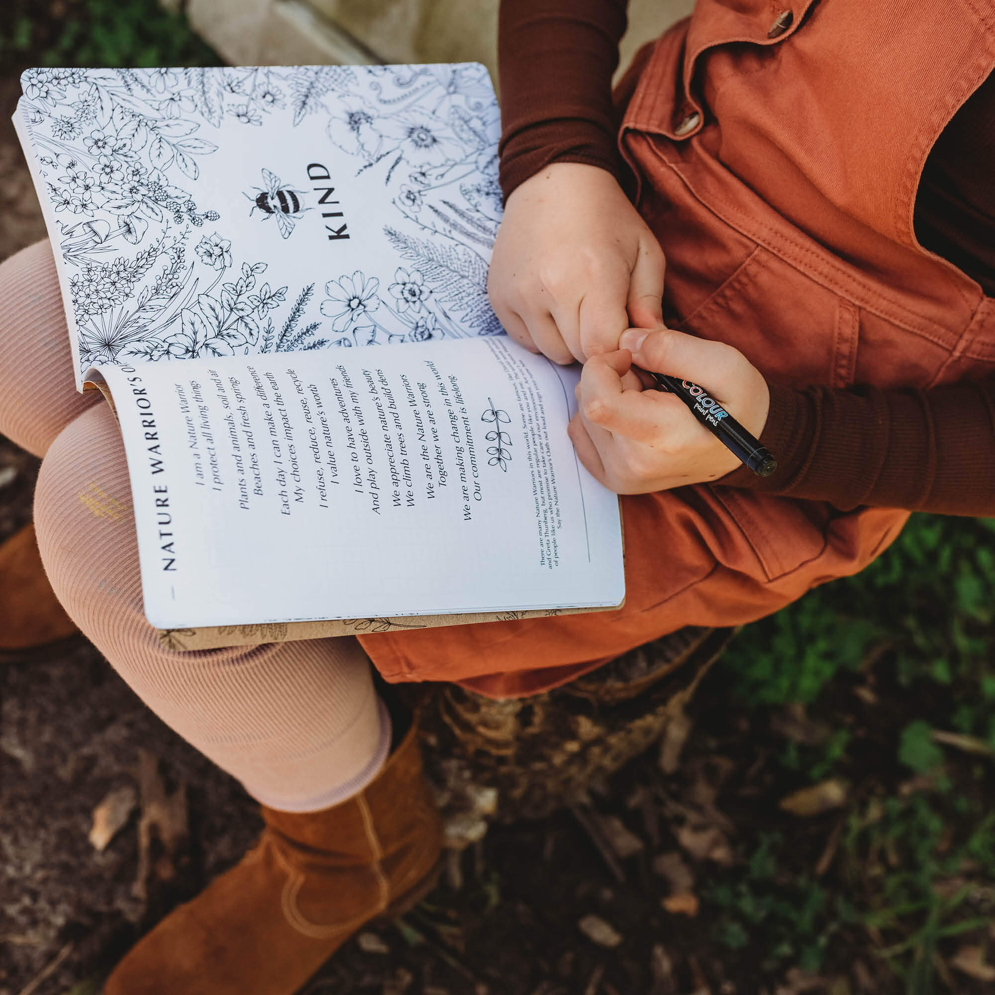 Child reading from Wild Nature Journal, a guided nature journal for kids and grown ups is made in Australia by Your Wild Books.