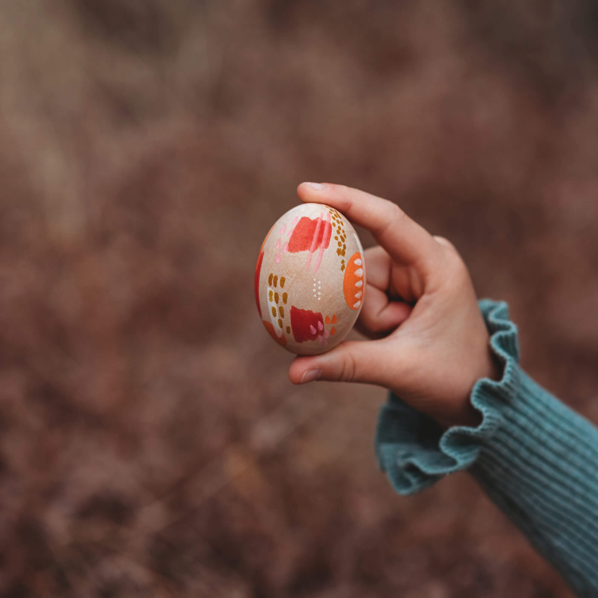 Large wooden eggs decorated with paint pens in Easter theme sugar free alternative to Easter eggs made by Your Wild Books