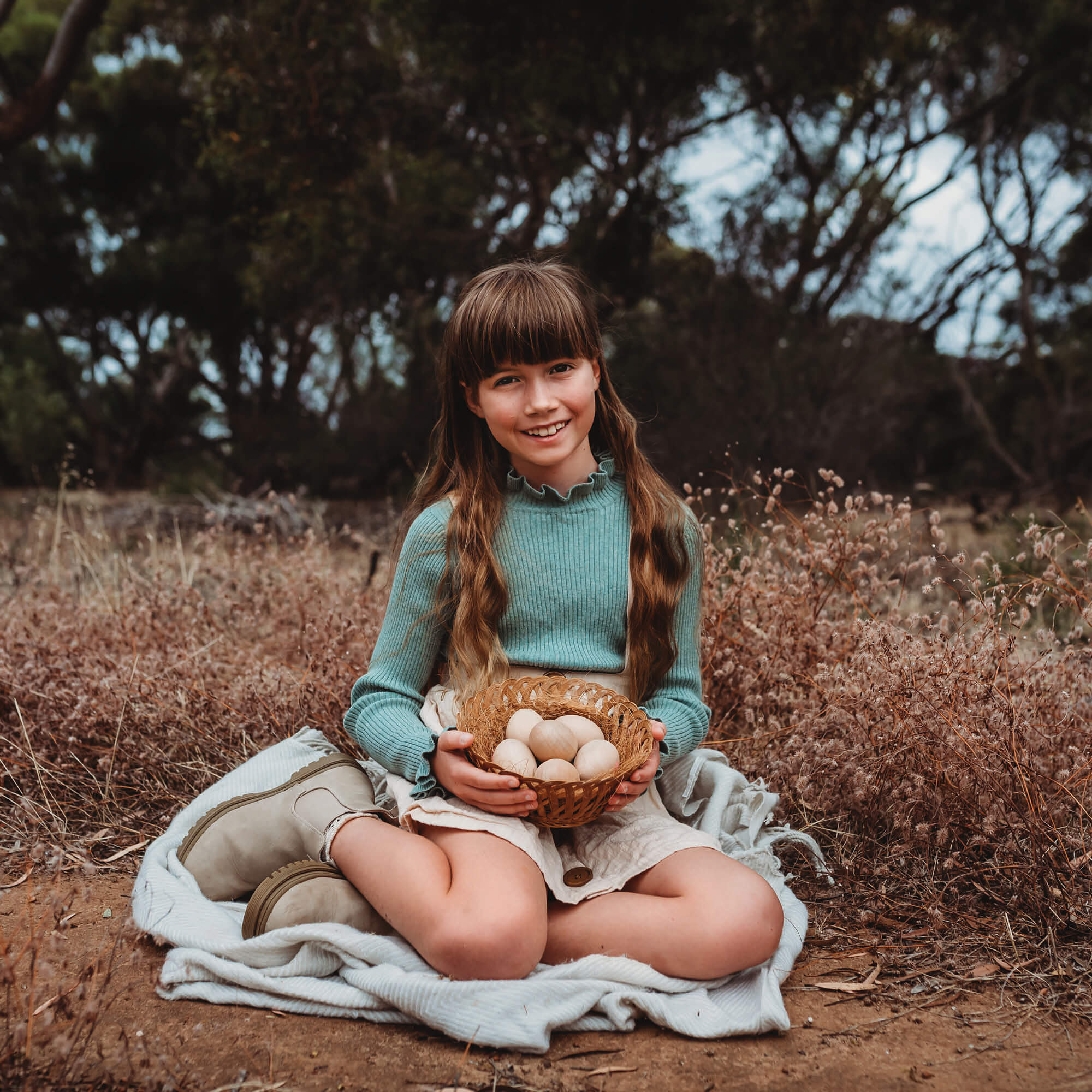 Girl holding a basket of large wooden eggs for craft sugar free alternative to Easter eggs made by Your Wild Books