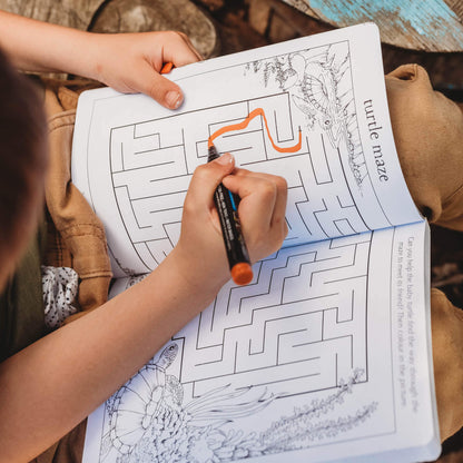 Child completing a maze with a turtle from the book, My First Wild Activity Book for kids 4-7 years who are learning to read, featuring nature inspired games and puzzles.