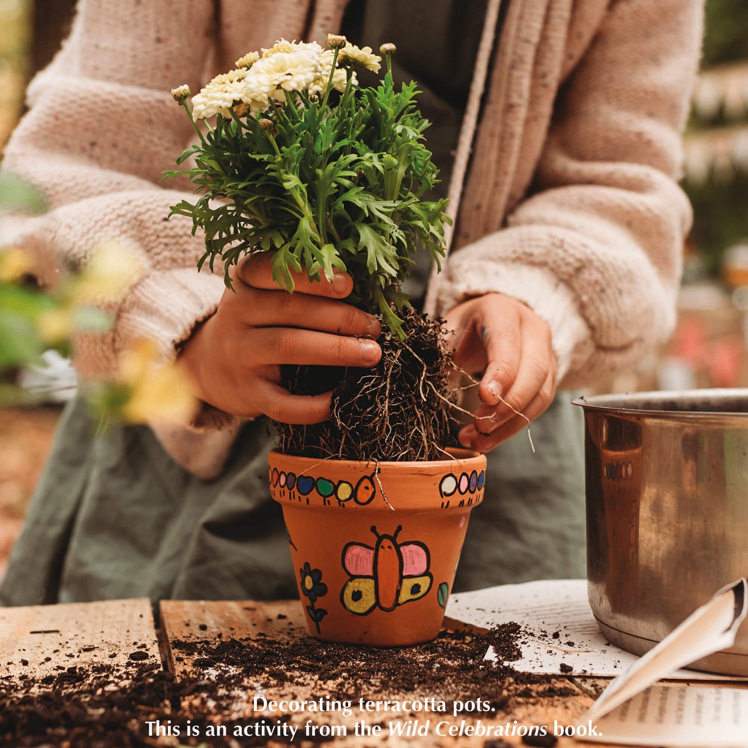 Decorating a terracotta pot, a nature craft activity from Your Wild Books that have been decorated with paint pens from Life of Colour