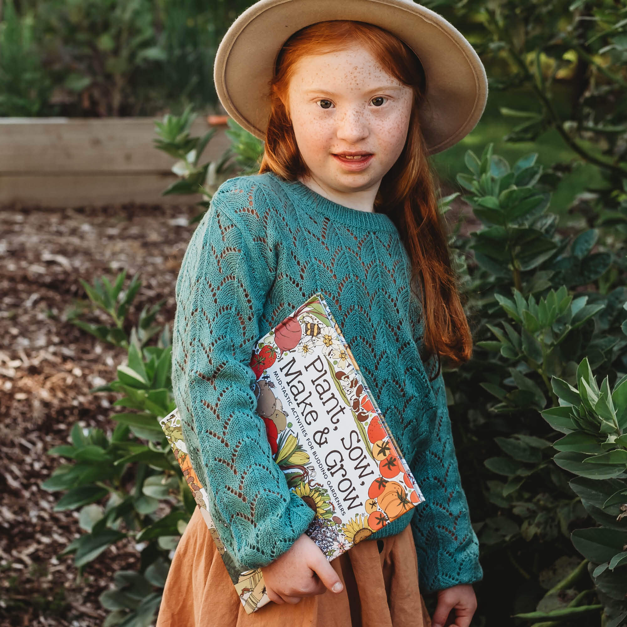 Girl holding Plant, Sow, Make and Grow kids gardening book by Esther Coombs from Your Wild Books.