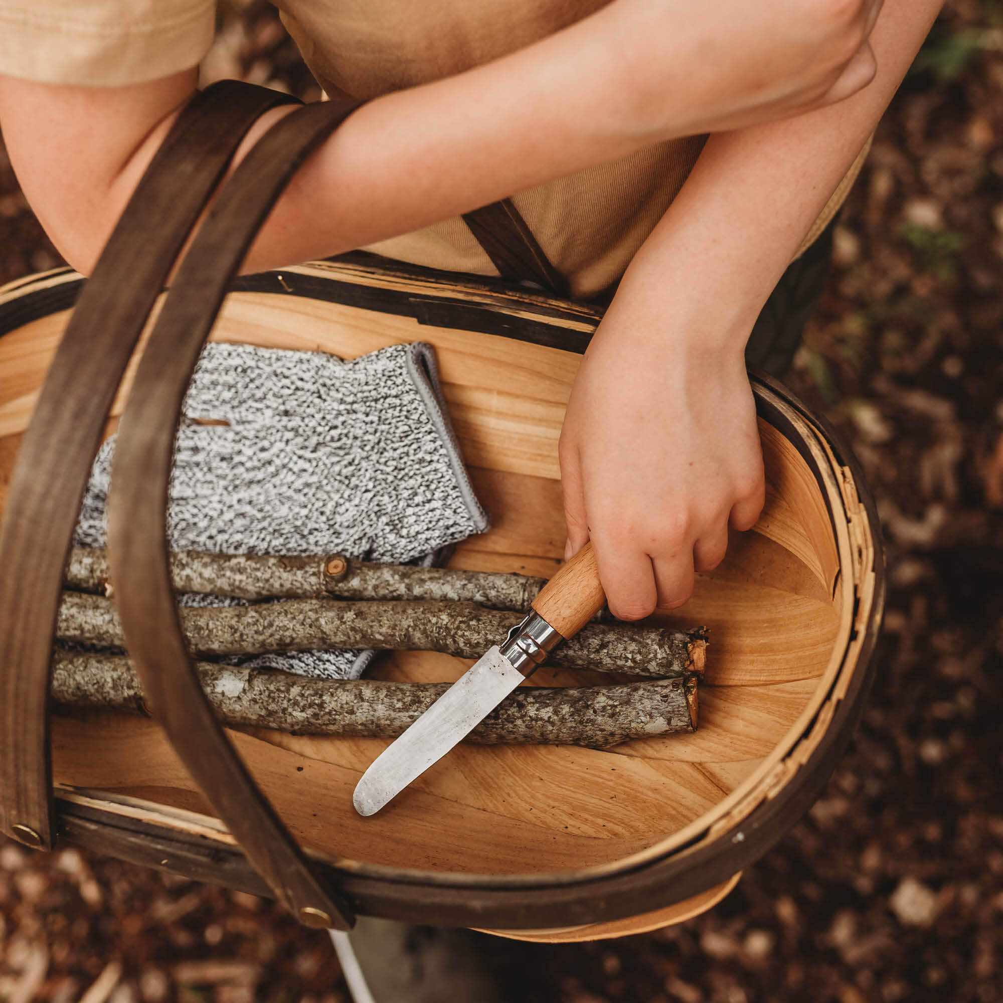 Child holding wood whittling knives for kids for all your nature craft projects, suitable for beginners and advanced woodworkers. Made by Opinel from Your Wild Books.