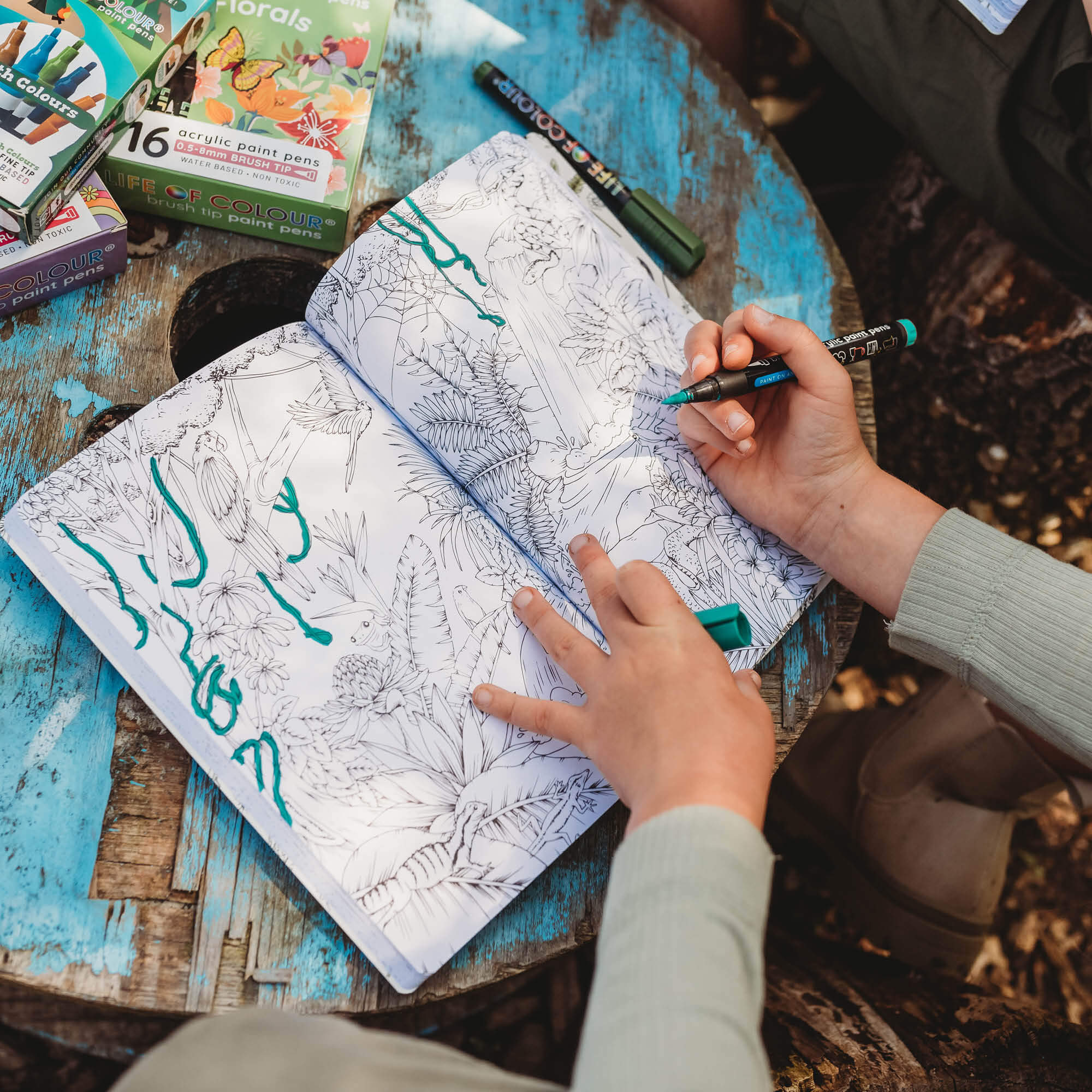 Pages showing a detailed colouring in of a rainforest from the book, Wild Activity Book for kids 7+ with nature inspired games and puzzles.