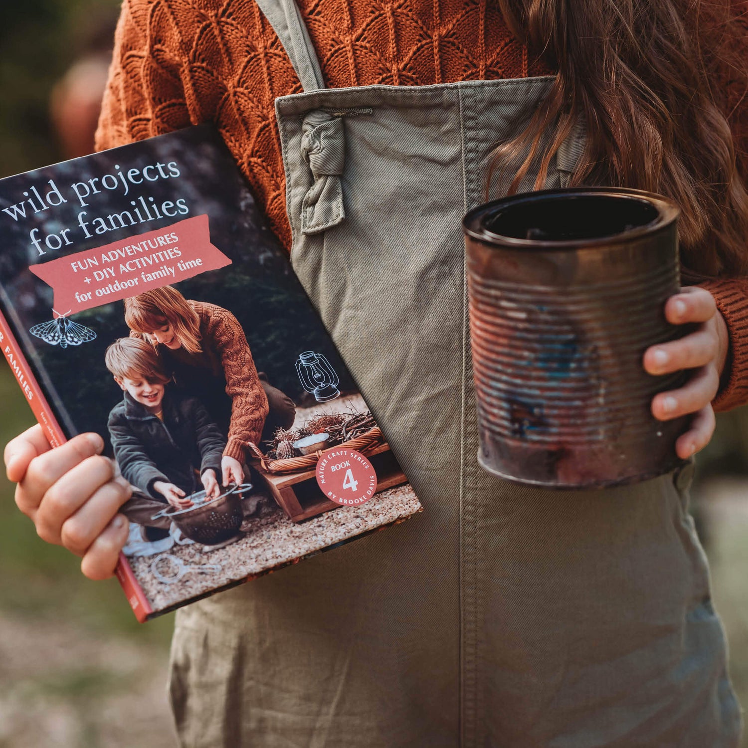 Child holding tin of DIY homemade charcoal and Wild Projects for Families book has fun adventures and DIY activities for family outdoor time, is made in Australia by Your Wild Books.