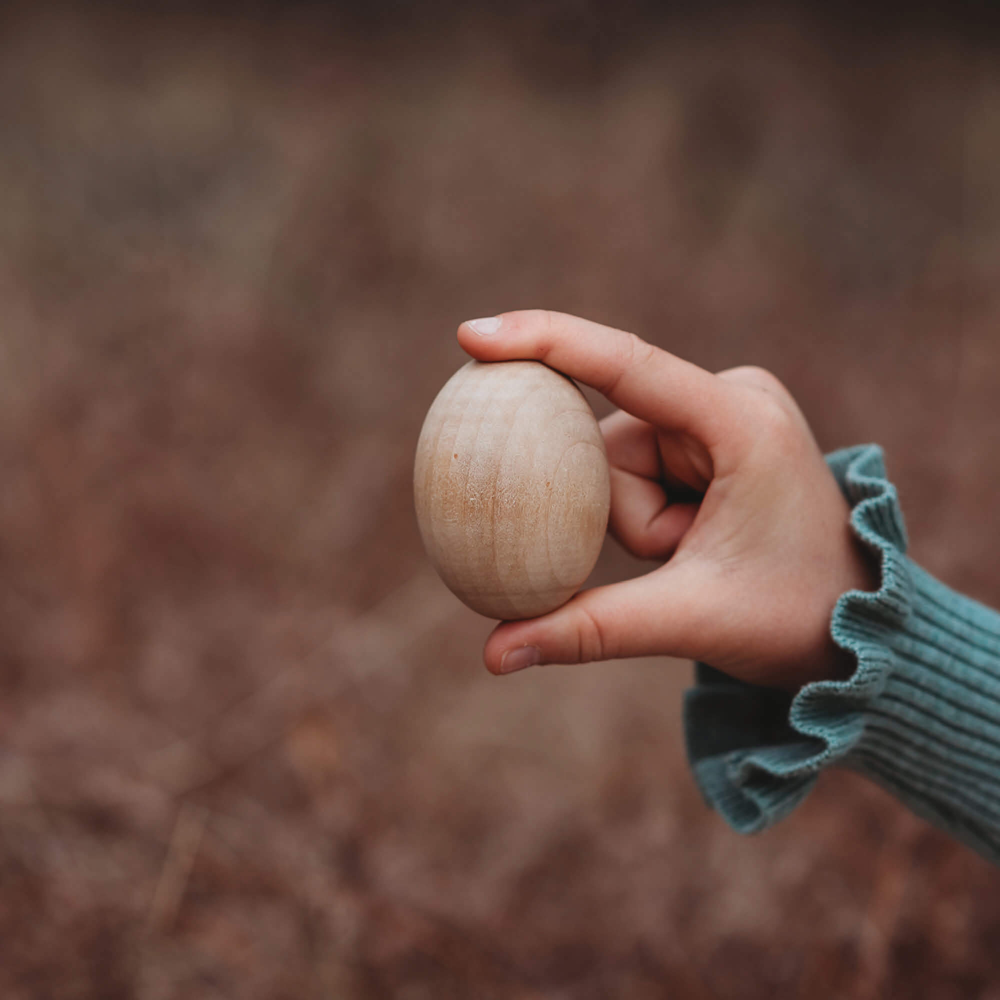 Girl holding large wooden egg for craft sugar free alternative to Easter eggs made by Your Wild Books