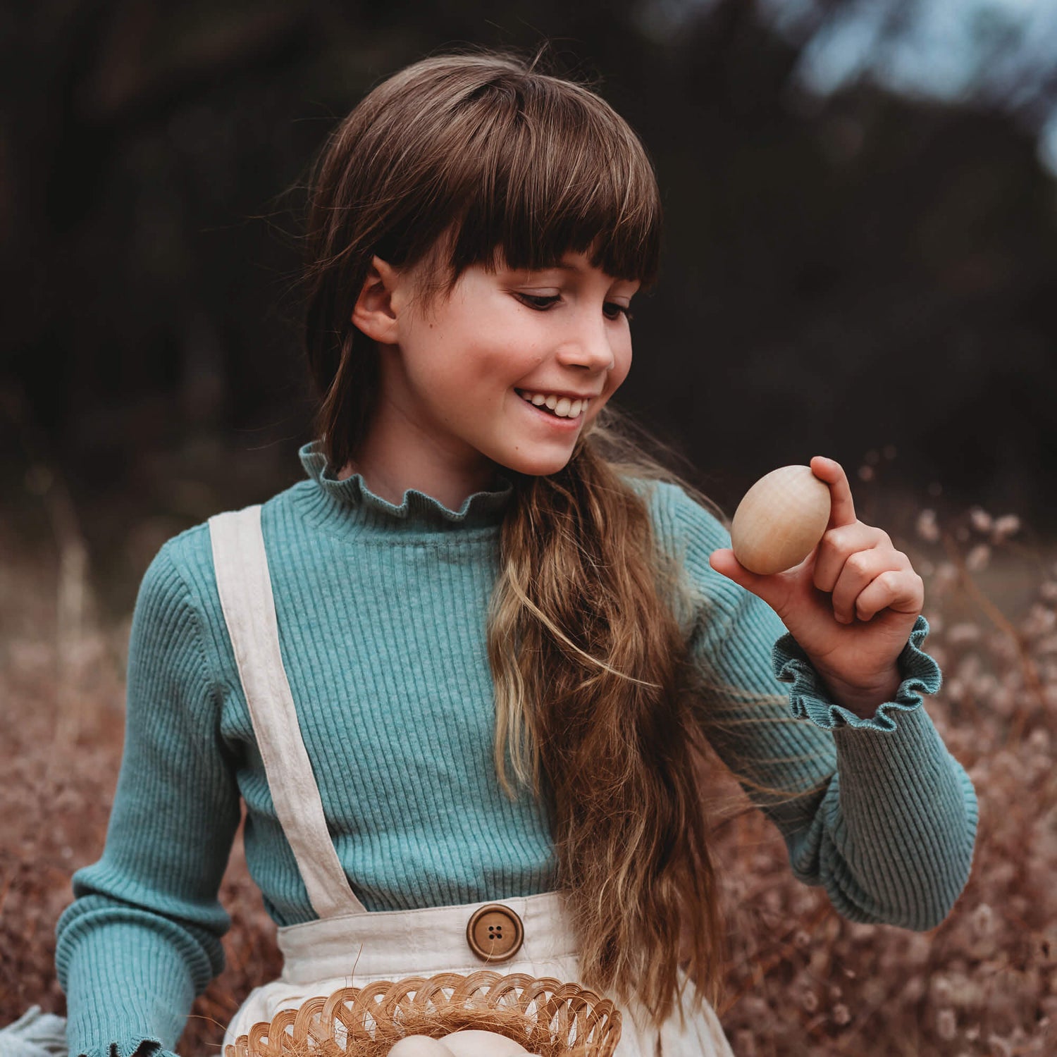 Girl holding large wooden egg for craft sugar free alternative to Easter eggs made by Your Wild Books